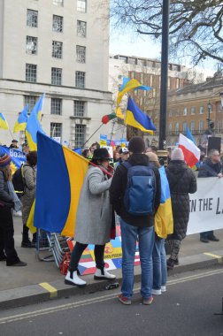 Londra 'daki insanlar Ukrayna' nın Rus işgalini protesto ediyorlar. Ukrayna bayraklarından feragat ediyorlar ve Ukrayna 'ya destek için bayrakları var..