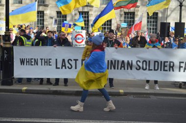 Londra 'daki insanlar Ukrayna' nın Rus işgalini protesto ediyorlar. Ukrayna bayraklarından feragat ediyorlar ve Ukrayna 'ya destek için bayrakları var..