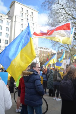 Londra 'daki insanlar Ukrayna' nın Rus işgalini protesto ediyorlar. Ukrayna bayraklarından feragat ediyorlar ve Ukrayna 'ya destek için bayrakları var..