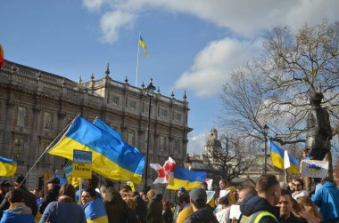 Londra 'daki insanlar Ukrayna' nın Rus işgalini protesto ediyorlar. Ukrayna bayraklarından feragat ediyorlar ve Ukrayna 'ya destek için bayrakları var..