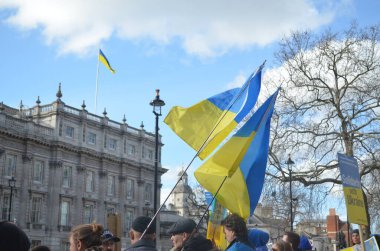 Londra 'daki insanlar Ukrayna' nın Rus işgalini protesto ediyorlar. Ukrayna bayraklarından feragat ediyorlar ve Ukrayna 'ya destek için bayrakları var..