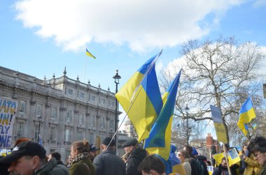 Londra 'daki insanlar Ukrayna' nın Rus işgalini protesto ediyorlar. Ukrayna bayraklarından feragat ediyorlar ve Ukrayna 'ya destek için bayrakları var..