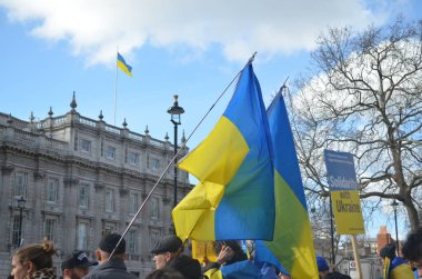 Londra 'daki insanlar Ukrayna' nın Rus işgalini protesto ediyorlar. Ukrayna bayraklarından feragat ediyorlar ve Ukrayna 'ya destek için bayrakları var..