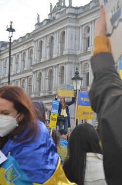 Londra 'daki insanlar Ukrayna' nın Rus işgalini protesto ediyorlar. Ukrayna bayraklarından feragat ediyorlar ve Ukrayna 'ya destek için bayrakları var..