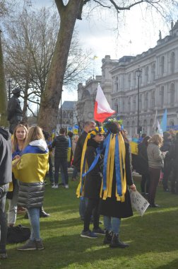 Londra 'daki insanlar Ukrayna' nın Rus işgalini protesto ediyorlar. Ukrayna bayraklarından feragat ediyorlar ve Ukrayna 'ya destek için bayrakları var..
