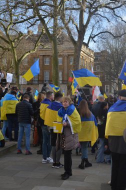 Londra 'daki insanlar Ukrayna' nın Rus işgalini protesto ediyorlar. Ukrayna bayraklarından feragat ediyorlar ve Ukrayna 'ya destek için bayrakları var..