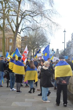 Londra 'daki insanlar Ukrayna' nın Rus işgalini protesto ediyorlar. Ukrayna bayraklarından feragat ediyorlar ve Ukrayna 'ya destek için bayrakları var..