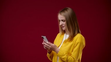 Kız telefondaki kaseti açtı ve hoş bir şekilde şaşırdı. Sarışın, kısa saçlı, kırmızı arka planda, beyaz tişört ve sarı gömlek giymiş.