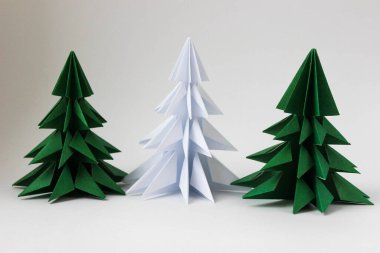 İki origami yeşil noel ağacı ve beyaz arka planda beyaz olan..