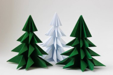İki origami yeşil noel ağacı ve beyaz arka planda beyaz olan..