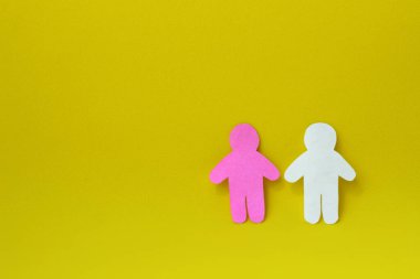 Beyaz ve pembe kağıtlardan oyulmuş iki insan silueti. İletişim, ilişkiler, aşk, takım çalışması kavramı