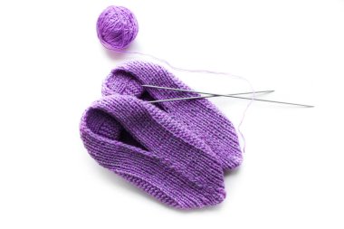 El yapımı pembe terlikler, örgü iğneleri ve iplik yumağı. Beyaz arkaplana kolayca metin ya da arkaplan değiştirebilirsiniz