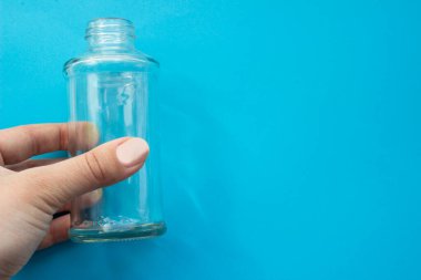 Tasarımınız için mavi zemin üzerinde şeffaf cam boş şişe.