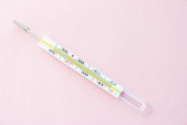 Pembe arka planda cıva termometresi. Tek nesne