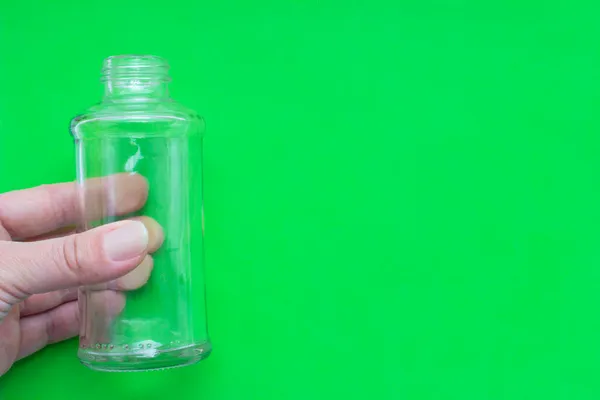 Прозрачный Стакан Пустая Бутылка Руке Зеленом Фоне Местом Вашего Дизайна — стоковое фото