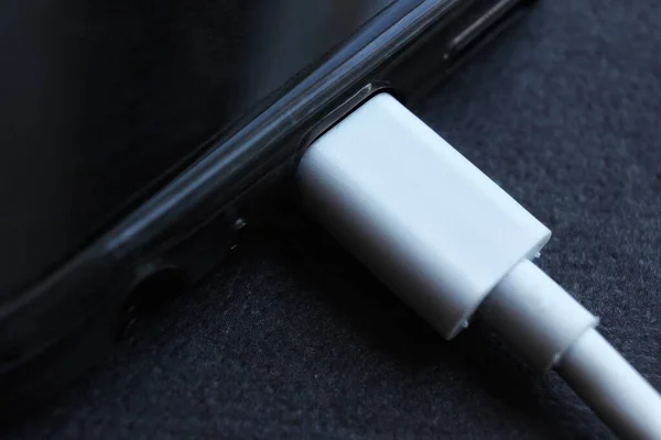 スマートフォンと挿入されたワイヤ内のUsb Type Cコネクタの閉鎖 急速充電だ 黒の背景に黒の放電電話 — ストック写真