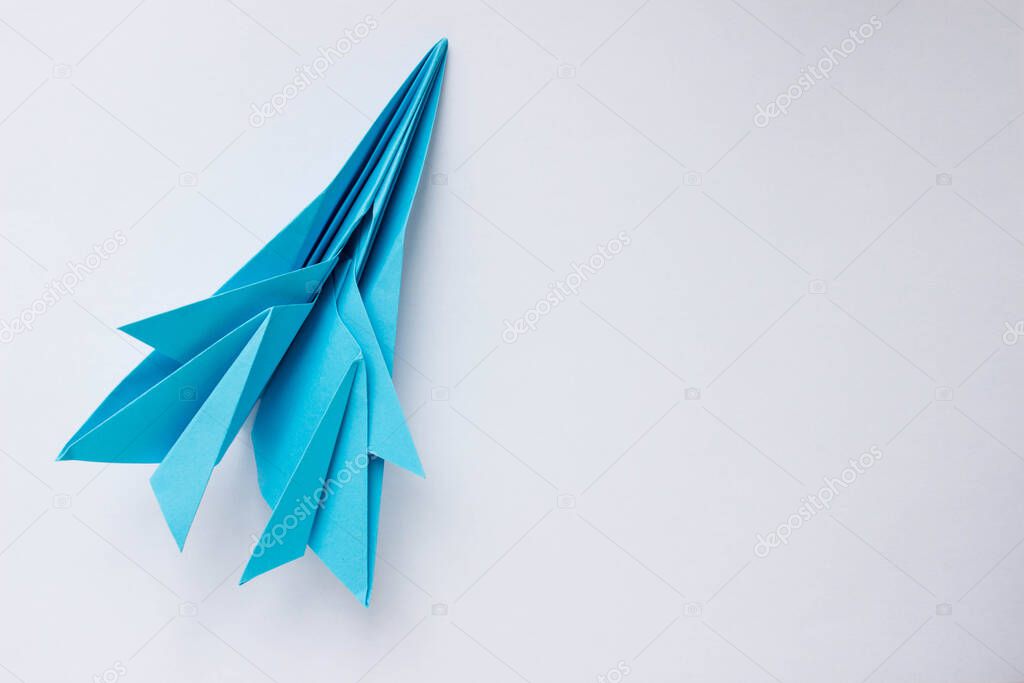 Blue paper origami plane on a white background. Background with place for text