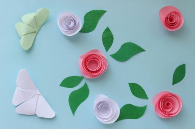 Origami kağıdında kelebekler, çiçekler ve yapraklar var. Origami kompozisyonu. Kağıt işçiliği