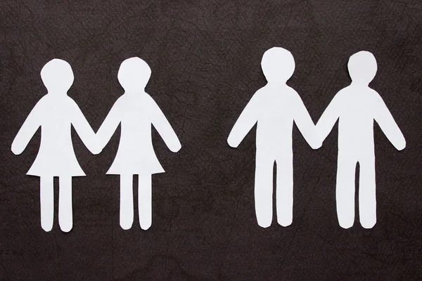 Deux couples homosexuels de personnes tenant la main coupant du papier blanc sur fond noir. Deux femmes et deux hommes. Concept d'amour homosexuel, relation, identité de genre — Photo