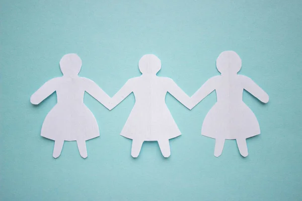 Trzy Dziewczyny Sukienkach Trzymające Się Ręce Wycięte Białego Papieru Środku — Zdjęcie stockowe