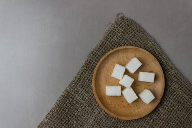 Mutfak masasının ortasında tahta bir tabakta şeker küpleri. Kopyalama alanı ile