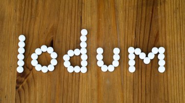 Ahşap arka planda iyot hapları. Tiroid bezi ve tiroit kanseri konsepti. Nükleer radyasyon hastalığını önleme. Sağlık ve tıp konsepti. Yüksek kalite fotoğraf