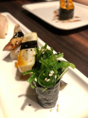 Japon suşili tabak ve masada suşi rulosu.