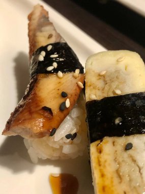 İki parça suşi conger yılanbalığı ve yumurta omleti.