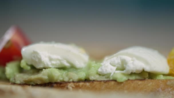 Makro záběr na vaření, dát plátek cherry rajče na bruschetta. — Stock video