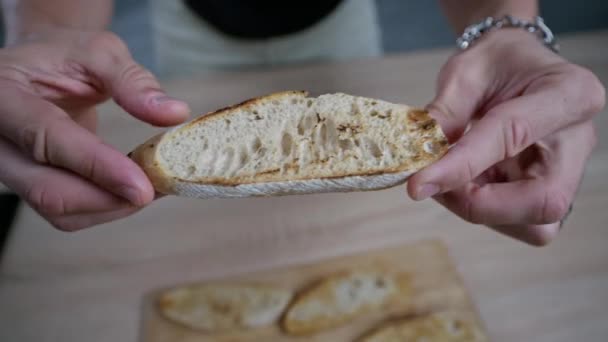 Ο τύπος βάζει τηγανητό ψωμί, μπρουσκέτα στον πίνακα. Σπιτικό μαγείρεμα — Αρχείο Βίντεο