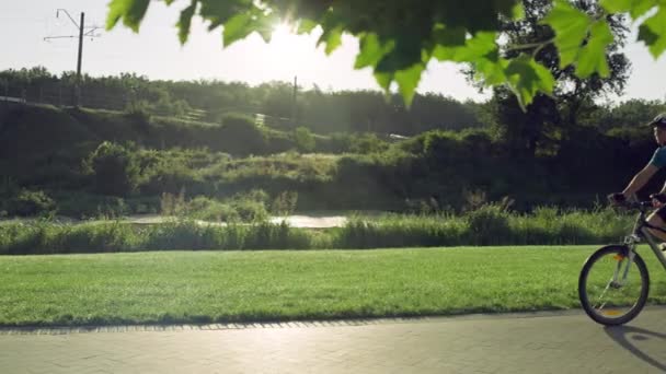 Der Typ fährt Fahrrad im Park. — Stockvideo