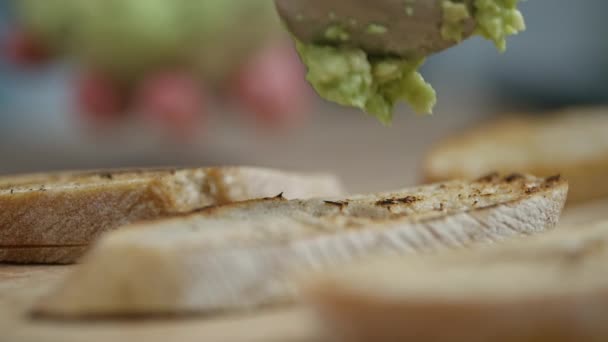 Elaboración de bruschettas, trituradas con aguacate sobre pan tostado — Vídeo de stock