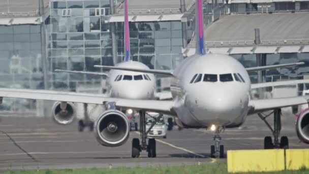 Los aviones están esperando en la cola para salir hacia la pista del aeropuerto. — Vídeos de Stock