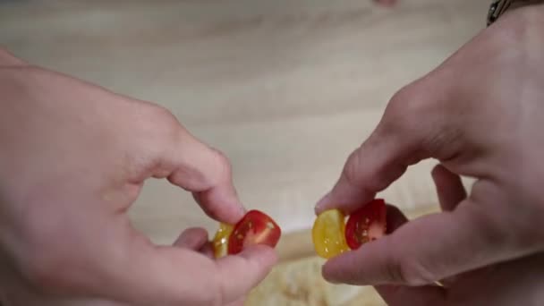 Повільне відео руху руки кладе вишневі помідори — стокове відео