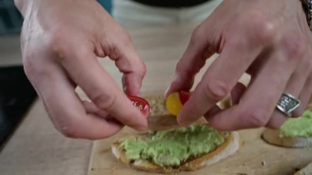 Mano pone tomates cherry en un sándwich de aguacate, — Vídeos de Stock