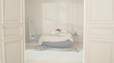 Kızın uyandığı yatak odasında sabah. Beyaz bir kız yataktan çıkıyor..