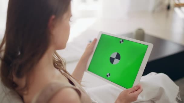 Девушка с помощью планшета с зеленым цветовым фоном — стоковое видео