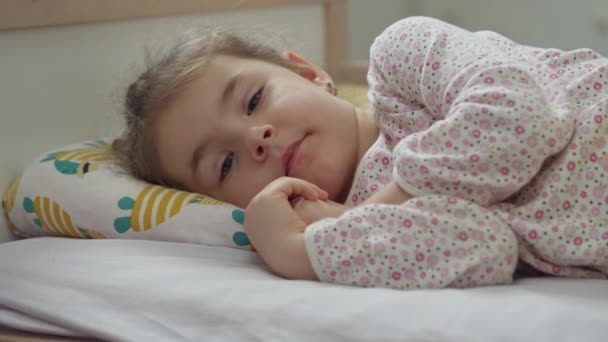 Una chica caucásica enferma está acostada en la cama. — Vídeo de stock