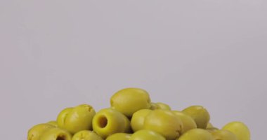 Yeşil zeytin. Beyaz arkaplanda dönen yağların olduğu bir çekim