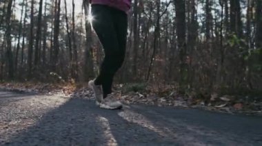 Park yolunda koşan bacakların yavaş çekim videosu. 