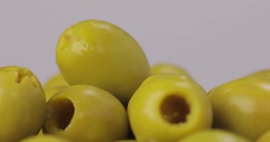 Yeşil zeytin. Beyaz arkaplanda dönen yağların olduğu bir çekim