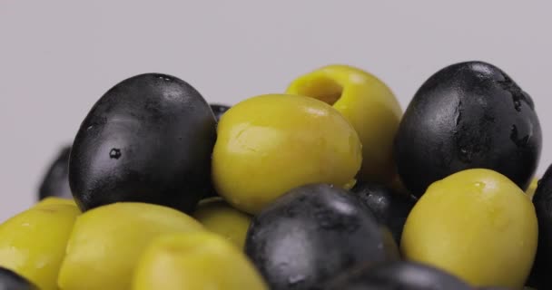 Groene olijven met zwarte olijven draaien op een witte achtergrond. — Stockvideo
