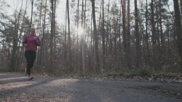 Καυκάσια γυναίκα που τρέχει στο δάσος του φθινοπώρου. — Αρχείο Βίντεο