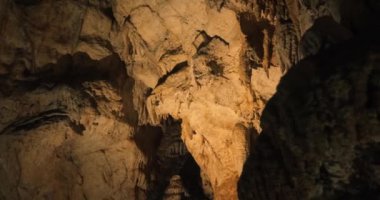 Dağın ortasındaki mağara manzarasında sarkıtlar ve dikitler var..
