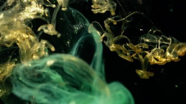 水の中で金と緑の色を混合するビデオ,色の泡. — ストック動画