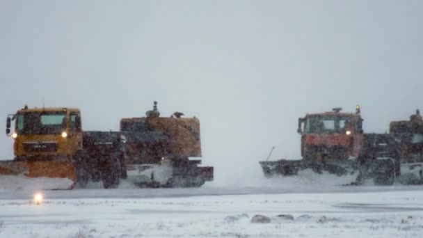 Специальное оборудование убирает снег с взлетно-посадочной полосы в метель — стоковое видео