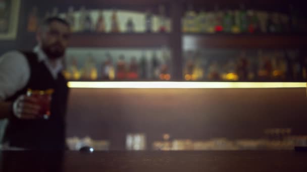 Barkeeper bringt einen orangefarbenen Martini auf den Tresen, — Stockvideo