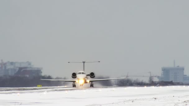 Небольшой бизнес-самолет взлетает с взлетно-посадочной полосы зимой в метель — стоковое видео