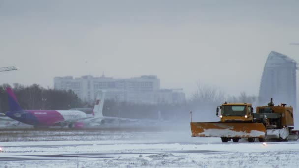 雪の降る日は空港の滑走路をきれいにする — ストック動画