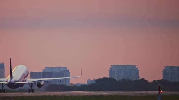 Avión despegando al amanecer en el aeropuerto con paisaje urbano. — Vídeo de stock
